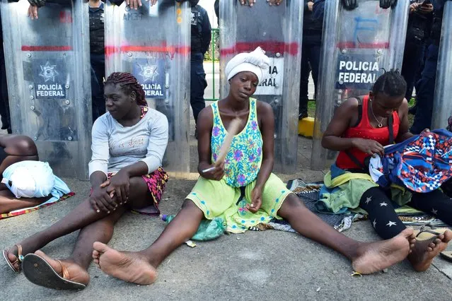Migrants from Haiti and Africa sit in front a barricade by riot police, as they protest outside the Siglo XXI immigrant detention center, demanding that Mexican migration authorities to speed up their humanitarian visas to cross the country towards the U.S., in Tapachula, Mexico on August 26, 2019. (Photo by Jose Torres/Reuters)