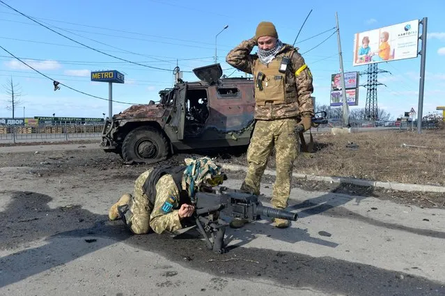 Ukrainian Territorial Defence fighters test the automatic grenade launcher taken from a destroyed Russian infantry mobility vehicle GAZ Tigr after the fight in Kharkiv on February 27, 2022. Ukrainian forces secured full control of Kharkiv on February 27, 2022 following street fighting with Russian troops in the country's second biggest city, the local governor said. (Photo by Sergey Bobok/AFP Photo)