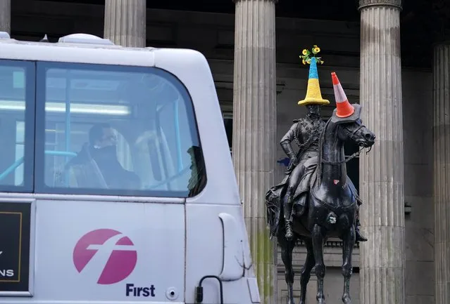 A bus passes the Duke of Wellington statue which has a traffic cone in the colours of the flag of Ukraine placed on top of the statue in front of Gallery of Modern Art (GoMA), the former mansion of Lord William Cunninghame of Lainshaw, in Glasgow on Monday, March 7, 2022. (Photo by Andrew Milligan/PA Images via Getty Images)