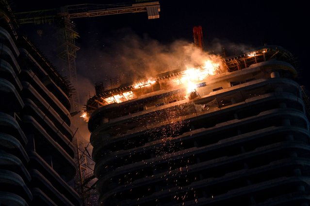 A fire burns on top of Tulipe Towers, an unfinished residential building in western Erbil, Iraq, 13 June 2024. The fire extended to other floors of the building without causing casualties so far, a local security official said. (Photo by Gailan Haji/ EPA)
