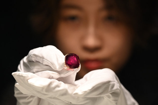 A representative from Sotheby's Hong Kong holds up the Estrela de Fura Ruby in Hong Kong on April 17, 2023. The Estrela de Fura Ruby, the largest and most valuable ruby ever to appear at auction (55.22 Carats) is expected to fetch at least 30 Million USD at Sotheby's New York in June. (Photo by Peter Parks/AFP Photo)