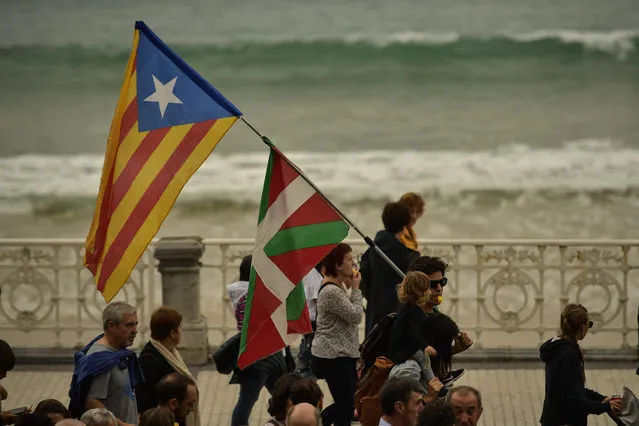 A man holds a Ikurrina or Basque flag close to Catalonia independence flag or “Estelada”, during a protest by Basque pro-independence activists in support of Catalonia's independence movement following Spain's conviction of Catalan separatist leaders, in San Sebastian, northern Spain, Saturday, October 19, 2019. Spain's Supreme Court on October 14 sentenced 12 prominent former Catalan politicians and activists of illegally promoting the Catalonia region's independence. (Photo by Alvaro Barrientos/AP Photo)
