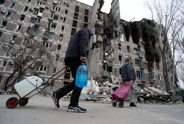 Local residents walk past an apartment building damaged during Ukraine-Russia conflict in the southern port city of Mariupol, Ukraine April 4, 2022. (Photo by Alexander Ermochenko/Reuters)