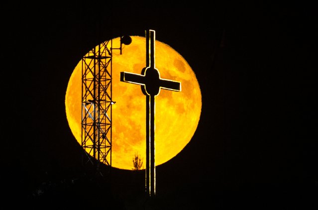 A full moon, also called Buck Moon, rises behind a 63.5 meters high cross, on a hill near Dracevo, Skopje, Republic of North Macedonia, 21 July 2024. (Photo by Georgi Licovski/EPA/EFE)