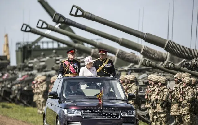 Britain's Queen Elizabeth II stands in an open top car during the Review of the Royal Artillery at Larkhill camp, England, Thursday May 26, 2016, as part of the Artillery's 300th anniversary. (Photo by Richard Pohle/Pool via AP Photo)