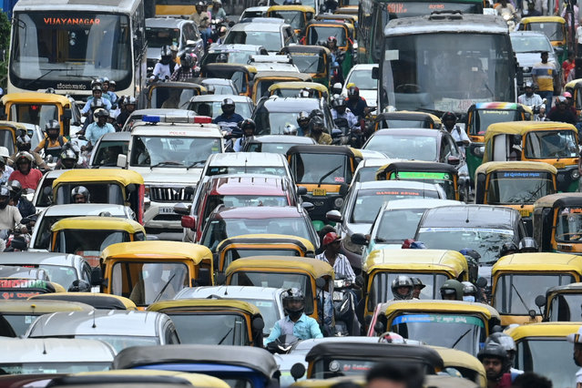 Commuters wait in a traffic jam along a road in Bengaluru on August 26, 2024. (Photo by Idrees Mohammed/AFP Photo)