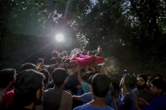 Kashmiris carry the body of rebel leader Sabzar Ahmed Bhat towards his home after displaying it to villagers in Tral area, 45 Kilometers south of Srinagar, Indian controlled Kashmir, Saturday, May 27, 2017. Bhat and a fellow militant were killed after troops cordoned off the southern Tral area overnight following a tip that rebels were hiding there, police said. (Photo by Dar Yasin/AP Photo)