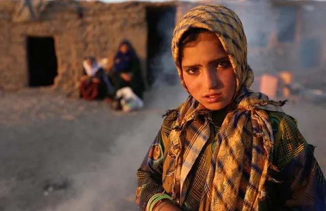 A young internally displaced from Faryab province poses for a picture near her temporary shelter at an Internally Displaced Persons (IDPs) camp on the outskirts of Herat, Afghanistan, 13 October 2015. (Photo by Jalil Rezayee/EPA)