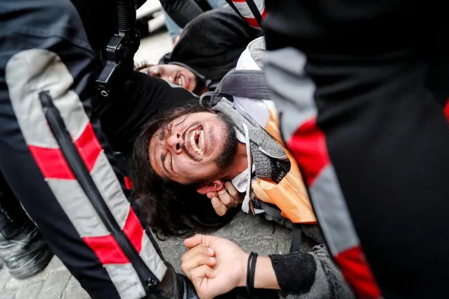 Police officers detain a protester who attempted to defy a ban and march on Taksim Square to celebrate May Day in Istanbul, Turkey on May 1, 2022. (Photo by Kemal Aslan/Reuters)