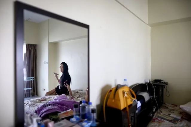 A picture made available on 22 June 2016 shows Myanmar make-up artist Ma Htet listening to music on a mobile phone as she recovers at a friend's apartment after undergoing gender reassignment surgery in Bangkok, Thailand, 20 April 2016. According to media reports, Thailand, a popular overseas destination for patients seeking for s*x-reassignment surgery, is leading in the growing practice of transgender surgery with low-cost health care and surgeons trained to perform male-to-female procedures. (Photo by Diego Azubel/EPA)