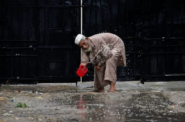 A man clears water from the entrance of an office after rain in Karachi, Pakistan, June 29, 2016. (Photo by Akhtar Soomro/Reuters)