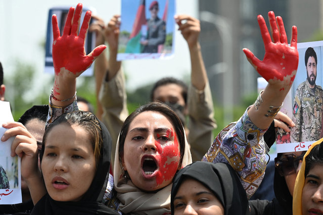 Afghan nationals carry placards as shout slogans during a demonstration against the Taliban government in Islamabad on August 15, 2023, on the occasion of the second anniversary of the Taliban takeover of Afghanistan. Afghanistan's Taliban government marked on August 15 the second anniversary of their takeover of the country with celebrations and a public holiday, issuing a defiant statement commemorating their surge back to power. (Photo by Aamir Qureshi/AFP Photo)