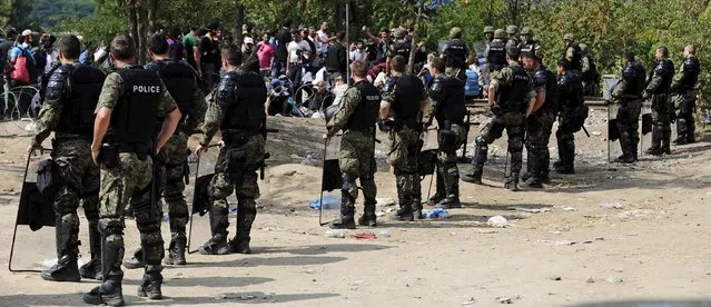 Macedonian special policemen guard the border as more than a thousand immigrants wait at the border line of Macedonia and Greece to enter Macedonia near the Gevgelija railway station August 21, 2015. (Photo by Ognen Teofilovski/Reuters)