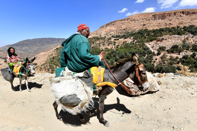 Farmers ride their donkeys near the destroyed village of Tikht, near Adassil, on September 10, 2023, two days after a devastating 6.8-magnitude earthquake struck the country. Moroccans on September 10 mourned the victims of a devastating earthquake that killed more than 2,000 people as rescue teams raced to find survivors trapped under the rubble of flattened villages. (Photo by Fethi Belaid/AFP Photo)