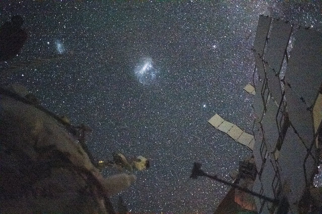 The Large Magellanic Cloud (center) and the Small Magellanic Cloud (upper left), dwarf galaxies in close proximity with the Milky Way galaxy, are pictured from the International Space Station, August 6, 2024. NASA astronaut and Expedition 71 Flight Engineer Matthew Dominick took this long-duration photograph with a station camera increasing its sensitivity to account for low light conditions. (Photo by NASA)
