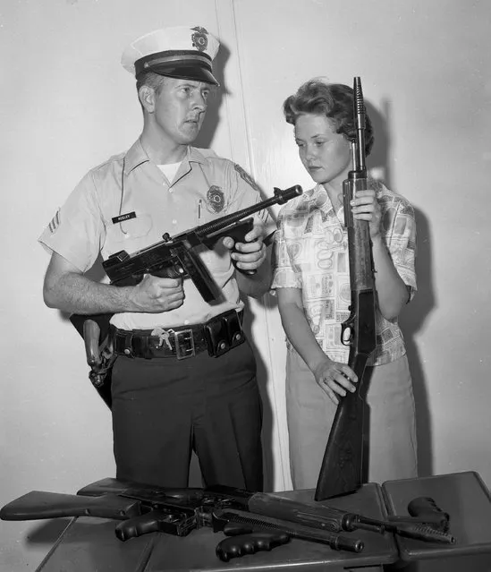 In this 1961 photo, Tucson Police Sgt. Tom Keeley holds a Colt Thompson submachine gun and secretary Linda Bradfield holds a Winchester Model 1907, with other guns confiscated from the John Dillinger gang during Dillinger's capture in Tucson, Ariz., in 1934. Police in Tucson are at odds with a small Indiana town over the Tommy gun taken from Dillinger during his arrest. The Arizona Daily Star reports that officials in Peru, Ind., want the Colt Thompson submachine gun turned over, saying they believe it was stolen from Peru police in 1933 before Dillinger was caught in Tucson. (Photo by Tucson Citizen Archive/Arizona Daily Star via AP Photo)