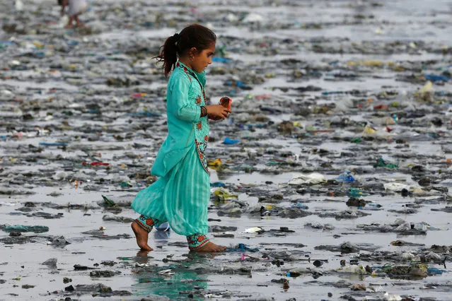 A girl walks through rubbish left by sea waves along Clifton beach in Karachi, Pakistan September 5, 2017. (Photo by Akhtar Soomro/Reuters)