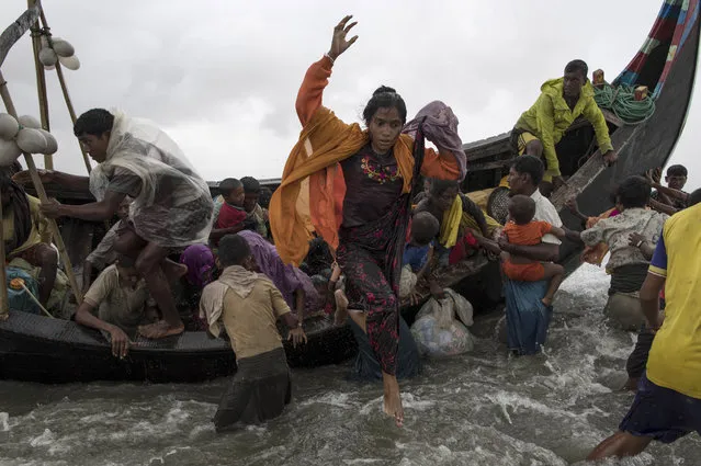 Rohingya refugees jump from a wooden boat as it begins to tip over after travelling from Myanmar, on September 12, 2017 in Dakhinpara, Bangladesh. Recent reports have suggested that around 290,000 Rohingya have now fled Myanmar after violence erupted in Rakhine state. The “Muslim insurgents of the Arakan Rohingya Salvation Army” have issued statement that indicates that they are to observe a cease fire, and have asked the Myanmar government to reciprocate. (Photo by Dan Kitwood/Getty Images)