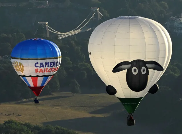 Balloons including one with a depiction of a sheep fly near the Clifton Suspension Bridge during a mass launch at the annual Bristol International Balloon Fiesta, near Bristol, Britain on August 12, 2022. (Photo by Toby Melville/Reuters)