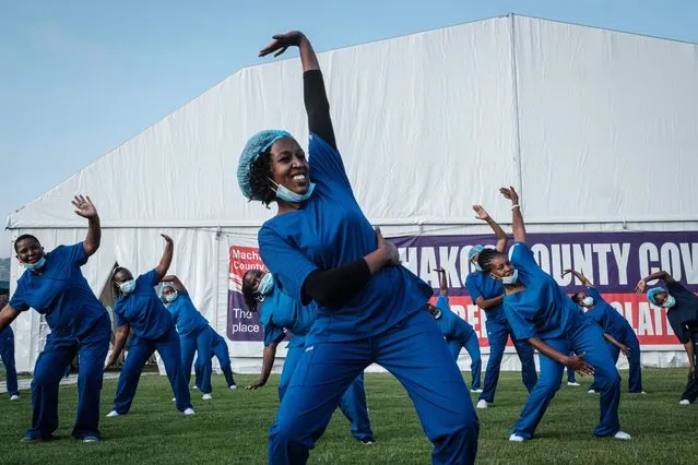 Health care providers – nurses, doctors, midwives and health care workers – attend the 4th Zumba dance session organised by the Nursing Council of Kenya at Kenyatta stadium where screening booths and isolation field hospital are installed for the COVID-19 coronavirus in Machakos, Kenya, on June 19, 2020. The Nursing Council of Kenya organizes dance sessions for health care providers to re-energize and uplift their sprits during this pandemic as a part of the celebration of 2020, the International Year of the Nurse and the Midwife by the World Health Organization (WHO). (Photo by Yasuyoshi Chiba/AFP Photo)
