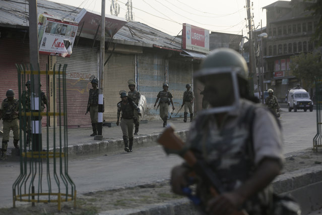 Indian paramilitary soldiers walk back towards their camp after a day long curfew in Srinagar, Indian controlled Kashmir, Sunday, August 21, 2016. Security lockdown and protest strikes continued for the 44th straight day Sunday, with tens of thousands of Indian armed police and paramilitary soldiers patrolling the tense region. The killing of a popular rebel commander on July 8 sparked some of Kashmir's largest protests against Indian rule in recent years. (Photo by Mukhtar Khan/AP Photo)