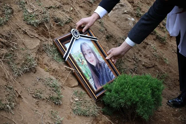 A portrait of Jung Joo-hee, 30, who were one of the victims of a crowd crush that happened during Halloween festivities, is placed at her grave in Namyangju, South Korea on November 3, 2022. (Photo by Kim Hong-Ji/Reuters)