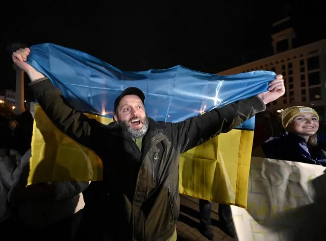 A man holds a Ukranian flag as people gather in Maidan Square to celebrate the liberation of Kherson, in Kyiv on November 11, 2022, amid the Russian invasion of Ukraine. Ukraine's President Volodymyr Zelensky said on November 11 that Kherson was “ours” after Russia announced the completion of its withdrawal from the regional capital, the only one Moscow captured in nearly nine months of fighting. (Photo by Genya Savilov/AFP Photo)