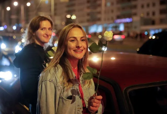 A woman holds a flower during an opposition rally to protest against police violence and to reject the presidential election results in Minsk, Belarus on August 13, 2020. (Photo by Vasily Fedosenko/Reuters)