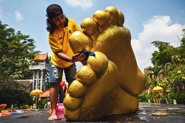 A worker cleans the reclining Buddha statue at the Maha Vihara Mojopahit temple in Mojokerto on May 7, 2025, ahead of the Vesak festival which commemorates the birth, enlightenment and death of Buddha. (Photo by Juni Kriswanto/AFP Photo)