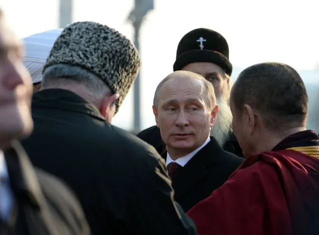 Russian President Vladimir Putin, center, speaks with the confessional leaders during a ceremony at the Red Square in Moscow on Tuesday, November 4, 2014, during the National Unity Day, a national holiday which this year marks the 402th anniversary of the 1612 expulsion of Polish occupiers from the Kremlin. (Photo by Vasily Maximov/AP Photo)
