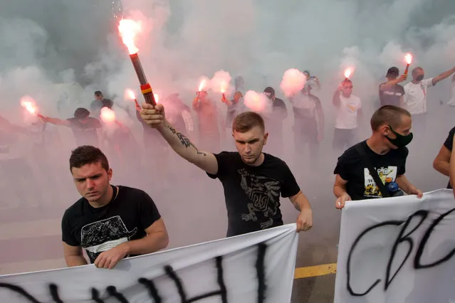 Protesters hold burning flares during the Defence of the Country is Not a Crime rally outside the Ministry of Internal Affairs, Kyiv, capital of Ukraine on September 3, 2020. Demonstrators call for the release of 16 people detained after an attack on a bus with the activists of the Patriots – For Life civil organisation on the highway near Liubotyn, Kharkiv Region, on August 27. (Photo credit should read Evgen Kotenko/Ukrinform/Barcroft Media via Getty Images)