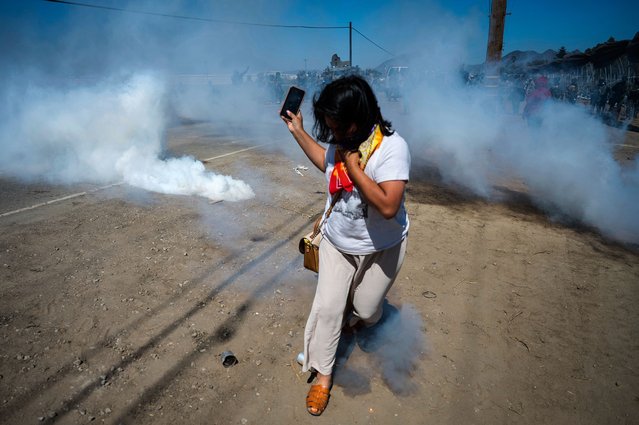 A protester runs from tear gas fired by federal immigration agents to clear a path for vehicles during a raid in an agricultural region of Camarillo, Calif., Thursday, July 10, 2025. (Photo by Michael Owen Baker/AP Photo)