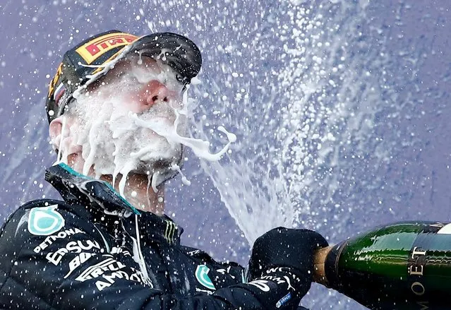 Mercedes' Valtteri Bottas celebrates with sparkling wine on the podium after winning the Formula One Russian Grand Prix at Sochi Autodrom in Sochi, Russia, September 27, 2020. (Photo by Maxim Shemetov/Pool via Reuters)