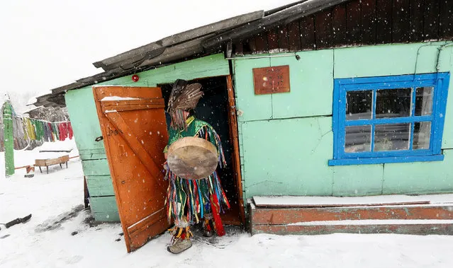 Duger Khomushku, shaman and head of the so-called Dungur society, leaves a wooden house before conducting a spiritualistic session with a customer on the exorcism of evil spirits at a courtyard of her residence in the town of Kyzyl, the administrative centre of the Republic of Tuva (Tyva region) in Southern Siberia, Russia November 3, 2016. The region is inhabited by Tuvans, historically cattle-herding nomads, who nowadays practise two main confessions – Buddhism and Shamanism. (Photo by Ilya Naymushin/Reuters)