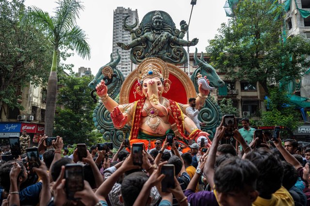Devotees carry an idol of the elephant-headed Hindu deity 'Ganesha' ahead of the Ganesh Chaturthi festival in Mumbai on July 20, 2025. (Photo by Punit Paranjpe/AFP Photo)