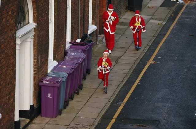 People dressed as Santa Claus walk down a road ahead of the start of the annual Santa Dash in Liverpool, northern England December 7, 2014. (Photo by Phil Noble/Reuters)