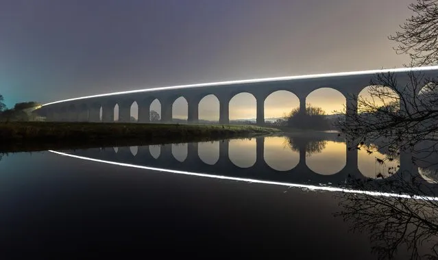 A train is photographed with a 30-second exposure as it crosses Arthington Viaduct in Yorkshire on January 24, 2023. (Photo by Andrew McCaren/London News Pictures)
