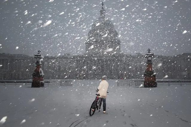 A bicyclist rides along the East Front Plaza during a snow storm on Capitol Hill in Washington, U.S., January 3, 2022. (Photo by Tom Brenner/Reuters)