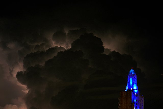 Lightning illuminates storm clouds beyond the Power and Light building in downtown Kansas City, Mo. Friday, August 16, 2024. (Photo by Charlie Riedel/AP Photo)