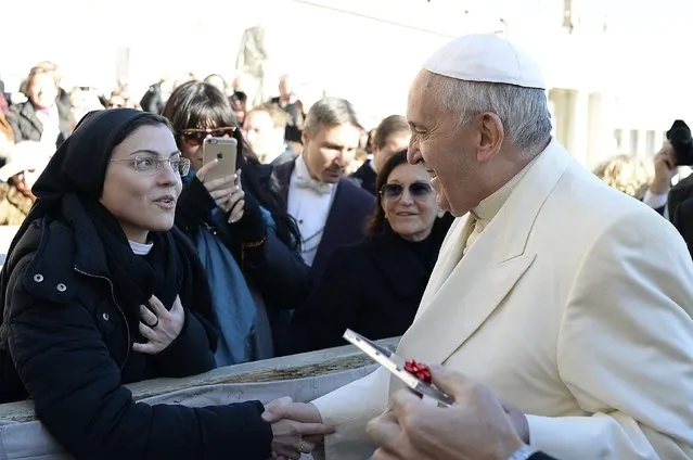 Pope Francis is presented with a music CD from Suor Cristina, an Italian nun and singer, during the weekly audience at the Vatican December 10, 2014. Suor Cristina won the 2014 season of “The Voice of Italy” singing competition. (Photo by Osservatore Romano/Reuters)