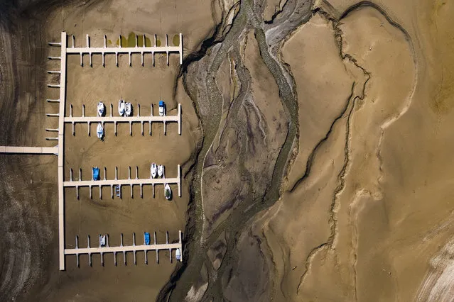 Stranded boats are pictured on the dried out shoes of the Lake of Gruyere in La Roche near Bulle, Switzerland, 14 March 2018. The level of the artificial impounding reservoir is progressively being brought down by 15 to 20m, planning for the upcoming melting of heavy snowfalls accumulated on the surrounding mountains. (Photo by Valentin Flauraud/EPA/EFE)