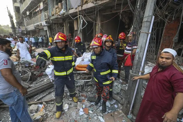 Fire officials carry a body of a victim after an explosion, in Dhaka, Bangladesh, Tuesday, March 7, 2023. (Photo by Abdul Goni/AP Photo)
