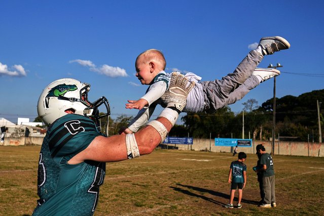 The Coritiba Crocodiles' Cleverson Kvas, a survivor of the 2024 team bus crash that killed three athletes, plays with his son Andre after a football game against the Brown Spiders in Curitiba, Brazil, Sunday, August 17, 2025. (Photo by Andre Penner/AP Photo)
