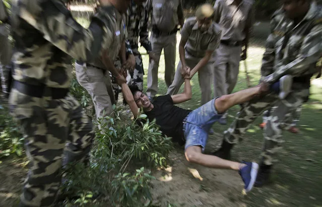 Indian police officers detain an exiled Tibetan youth activist during a protest outside the Chinese Embassy in New Delhi, India, Friday, October 14, 2016. The protest was held against the Chinese government's plan to demolish part of a revered Buddhist monastery in Larung Gar and against the visit of Chinese President Xi Jinping to attend the 8th BRICS Summit in Indian state of Goa on October 15 and 16. (Photo by Altaf Qadri/AP Photo)