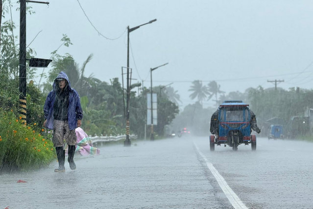 A man walks along a road amid heavy rain due to weather patterns from Super Typhoon Ragasa in Lal-lo town, Cagayan province on September 22, 2025. Hundreds of families sheltered in schools and evacuation centres on September 22 as heavy rains and gale-force winds from Super Typhoon Ragasa lashed the northern Philippines and southern Taiwan. (Photo by John Dimain/AFP Photo)