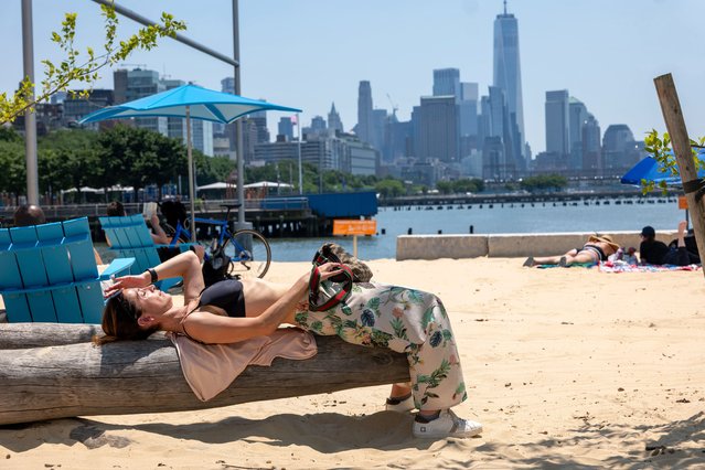 People relax at an artificial beach in Manhattan on a sweltering afternoon on the first full day of summer on June 21, 2024 in New York City. New York City and much of the Northeast is experiencing higher than usual temperatures as a heat wave blankets the area, causing the heat index to feel over 100 degrees in many states. Meteorologists are predicting that this could be one of the hottest summers on record. (Photo by Spencer Platt/Getty Images)