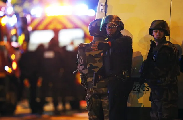 Security forces signal journalists to move back as they secure the area near the Bataclan concert hall following fatal shootings in Paris, France, November 13, 2015. (Photo by Christian Hartmann/Reuters)