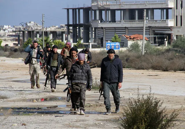 Rebel fighters walk around al-Hamidiyeh base, one of two military posts they took control of from forces loyal to Syria's President Bashar al-Assad in the northwestern province of Idlib, December 15, 2014. (Photo by Reuters/Stringer)