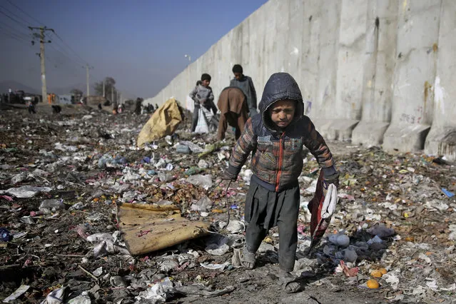 An internally displaced Afghan child looks for plastic and other items which can be used as a replacement for firewood, at a garbage dump in Kabul, Afghanistan, Sunday, December 15, 2019. According to UN statistics, Afghanistan is among the poorest countries in the world where children are subjected to extreme poverty and violence on a daily basis. (Photo by Altaf Qadri/AP Photo)