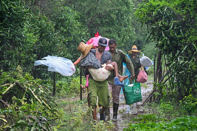 Residents self-evacuate under pouring rain from Playa Siboney to safe locations ahead of the arrival of Hurricane Melissa, in Santiago de Cuba, Cuba, on October 28, 2025.. (Photo by Yamil Lage/AFP Photo)